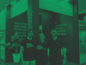 Foto com filtro verde do time da Clarke Energia na Vitória Stone Fair; da esquerda para a direita: Arthur Tkotz, head de vendas, Viviane Machado, head de marketing, e Pedro Rio, CEO