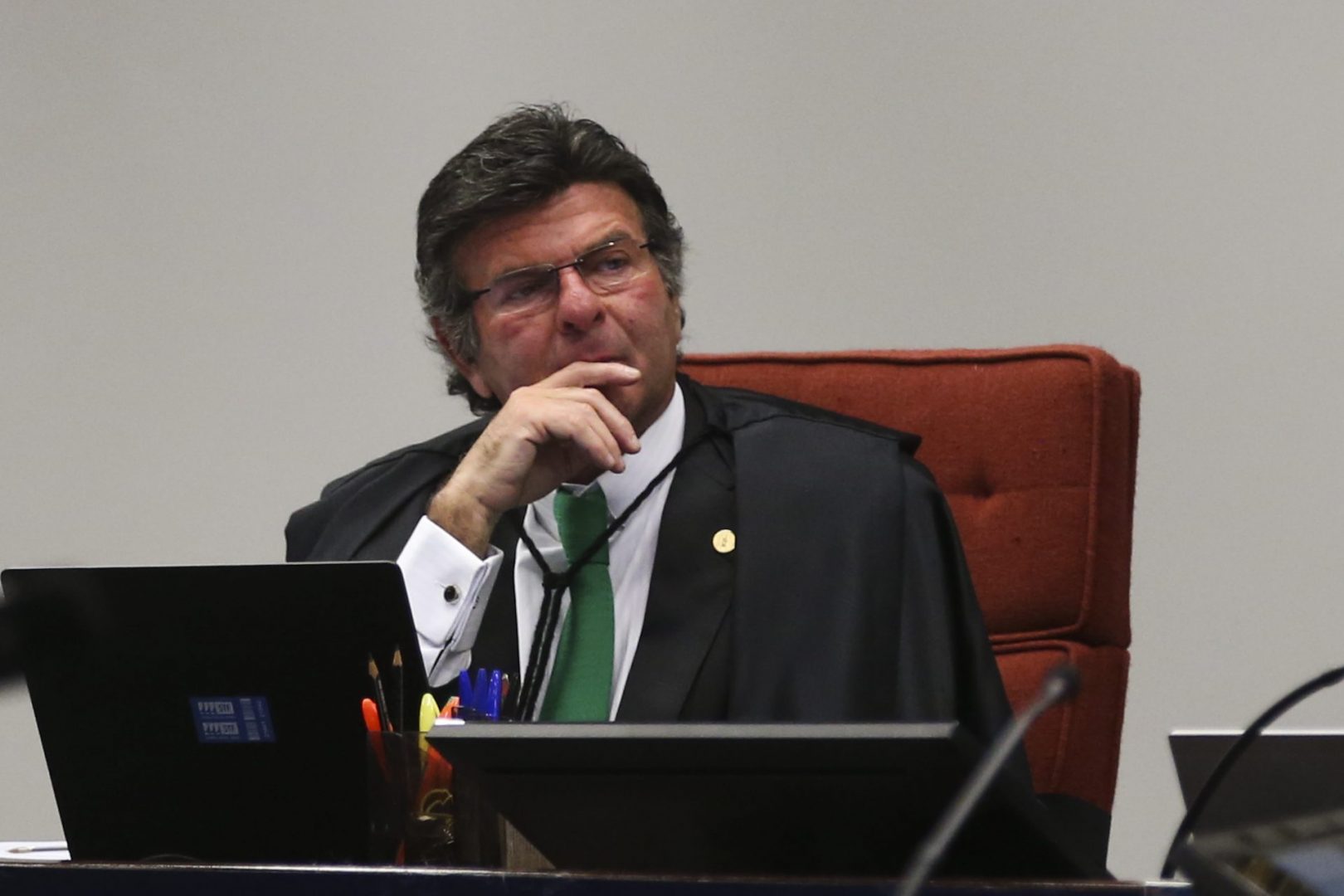 Ministro Luiz Fux, do Supremo Tribunal Federal (STF), aparece sentado em uma cadeira acolchoada em tons avermelhados, levando a mão ao rosto. Ele decidiou pela retomada a cobrança de ICMS sobre a transmissão e distribuição de energia.