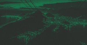 Foto com filtro verde da vista aérea da cidade do Rio de Janeiro à noite, com luzes acesas.