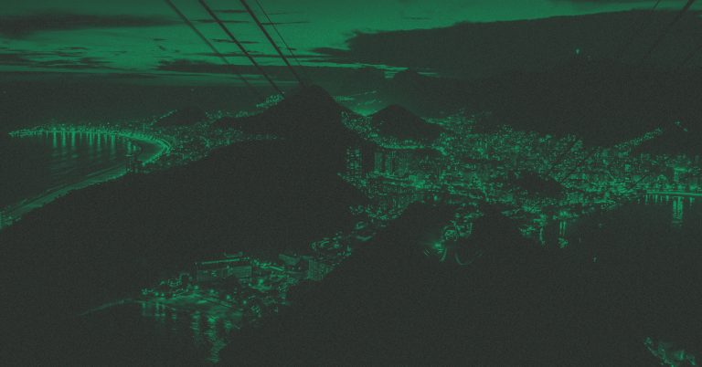 Foto com filtro verde da vista aérea da cidade do Rio de Janeiro à noite, com luzes acesas.