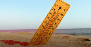 Um termômetro no chão de areia, simbolizando onda de calor