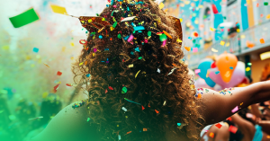 uma mulher com vários confetes no cabelo no meio do carnaval