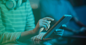 Mulher segurando o tablet e a logo da clarke